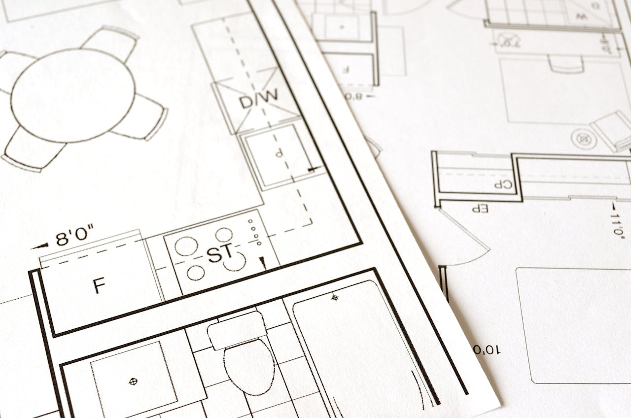 services-03 Close-up view of an architectural floor plan on paper showcasing detailed room layouts and measurements.